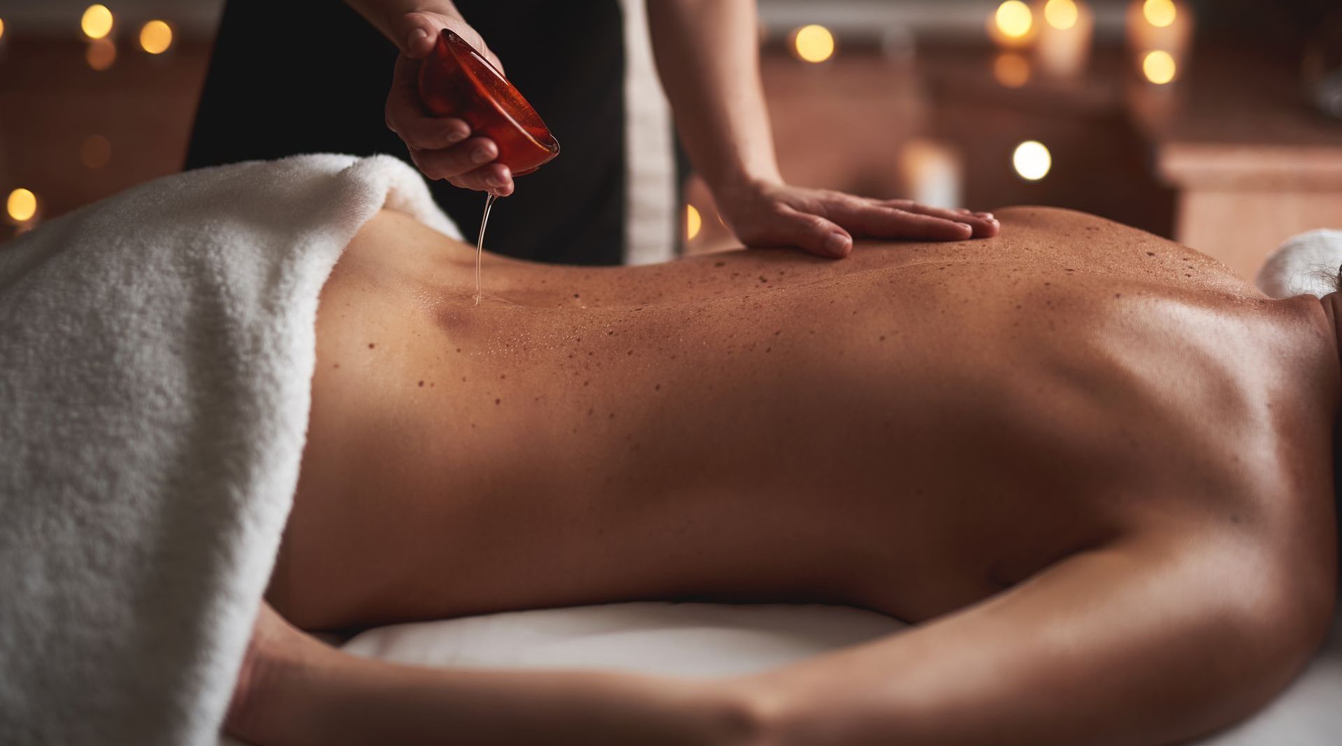 Young therapist pour essential oil out from bowl